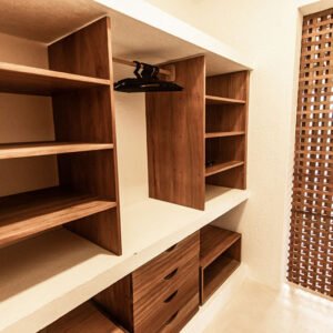 Closet da Casa Norte Preá com armários de madeira, nichos e bancada de apoio