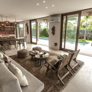 Sala de estar da Casa Norte Preá com sofás, decoração contemporânea e vista para o jardim e área externa