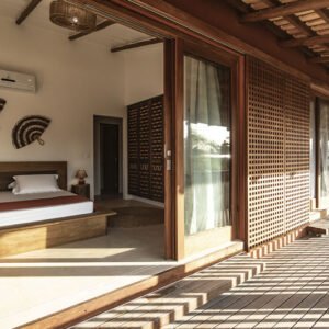Suíte da Casa Norte Preá com cama de casal, portas de madeira e acesso à área externa