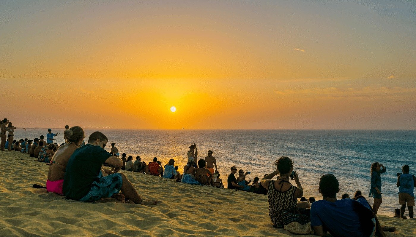 Trilha: Pôr do sol em Jericoacoara com visitantes contemplando a paisagem